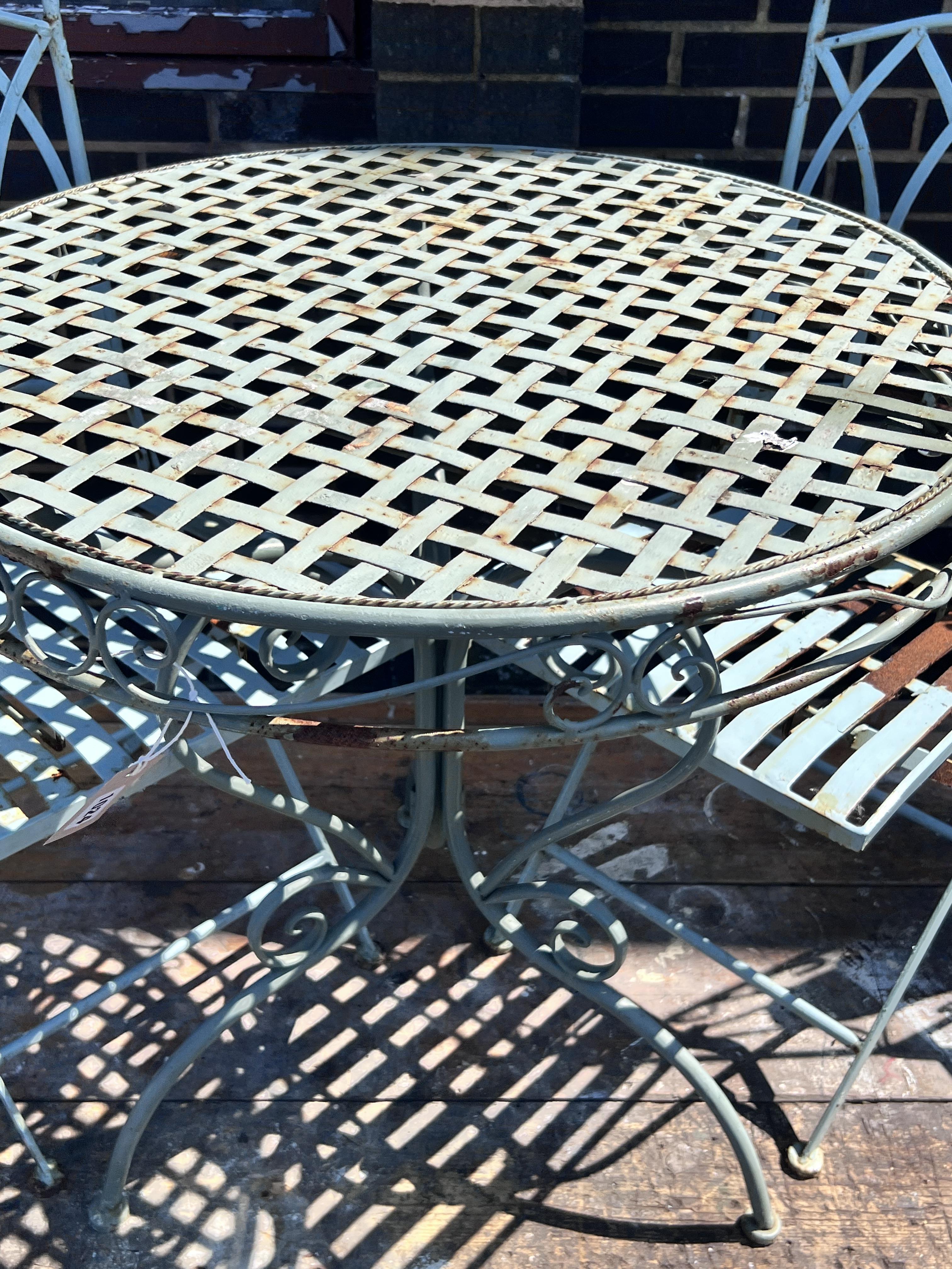 A circular painted metal garden table, diameter 70cm, height 74cm, and two chairs